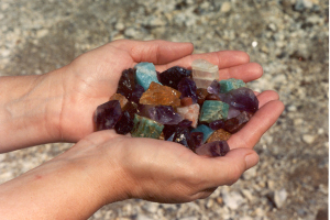Hands holding assorted gemstones