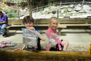 Two kids holding bags of gemstones