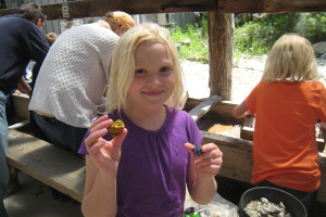 A smiling girl holding a gemstone