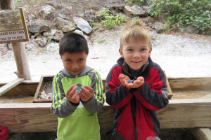 Two boys holding gemstones at the gemstone mine